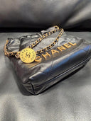 Sac à bandoulière seau mini 22 en cuir lisse noir - Chanel